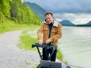 Amadeus Banerjee spielt als "LOOMINAS" ein DJ-Set am Sylvensteinsee.